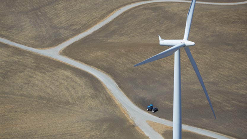 An open field with a wind turbine.