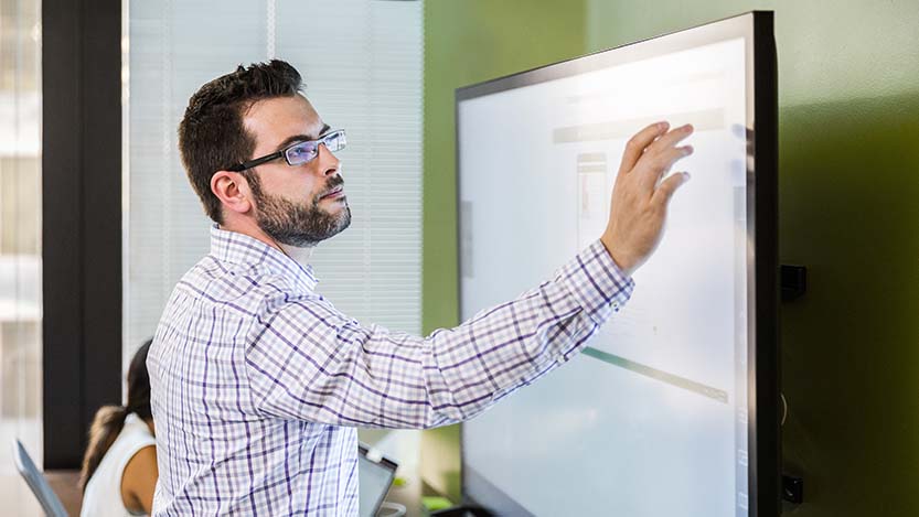 A man interacting with a touch screen.