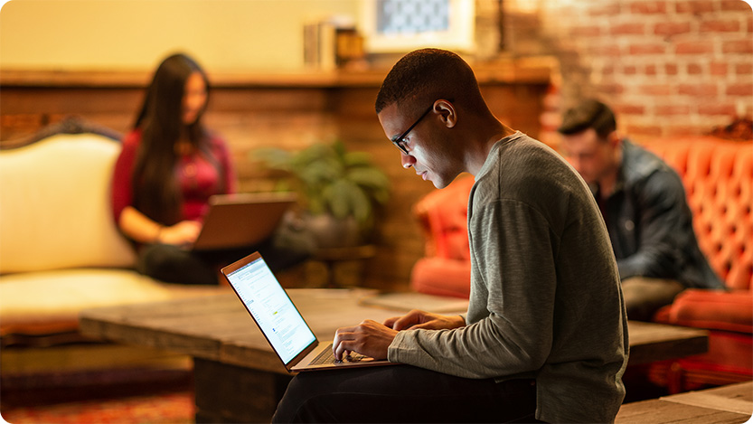  Male developer working remotely from a cafe.