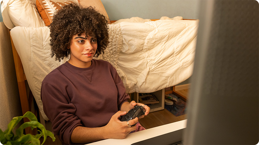 A college student immersed in her Xbox gaming session.